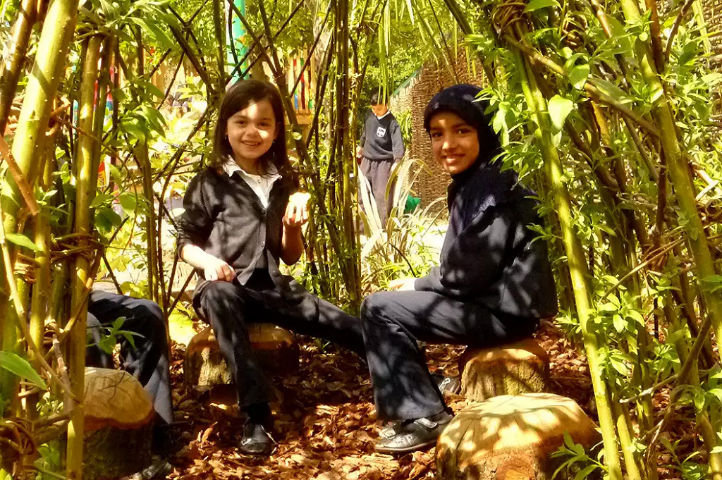 A Made From Scratch Project - Children smiling sitting in a bamboo grove